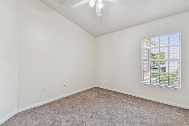 carpeted spare room featuring vaulted ceiling, baseboards, and ceiling fan