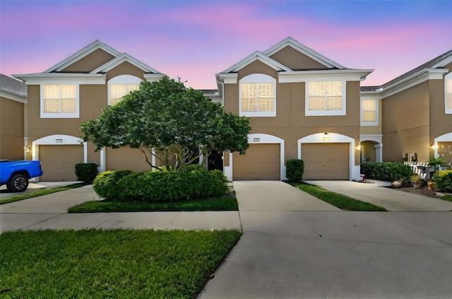 view of front of property with a garage, driveway, and stucco siding