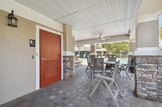 view of patio featuring a community pool and ceiling fan