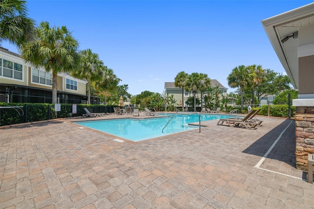 community pool with fence and a patio area