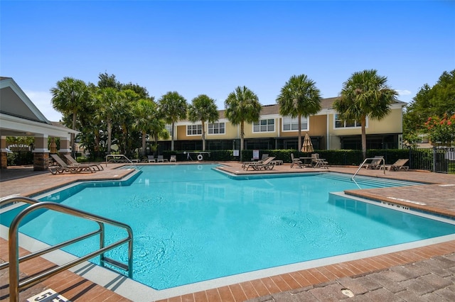 community pool featuring a patio area and fence