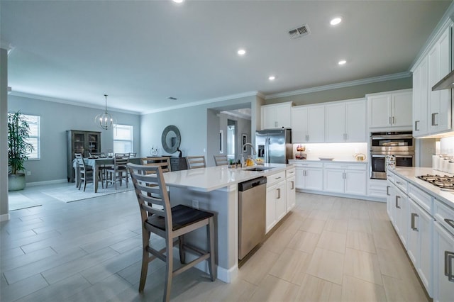 kitchen featuring crown molding, a sink, light countertops, white cabinets, and appliances with stainless steel finishes