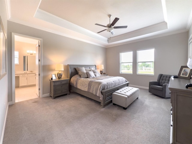 bedroom with crown molding, ensuite bathroom, a raised ceiling, light colored carpet, and baseboards