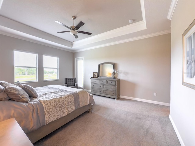 bedroom featuring light colored carpet, baseboards, a raised ceiling, and crown molding