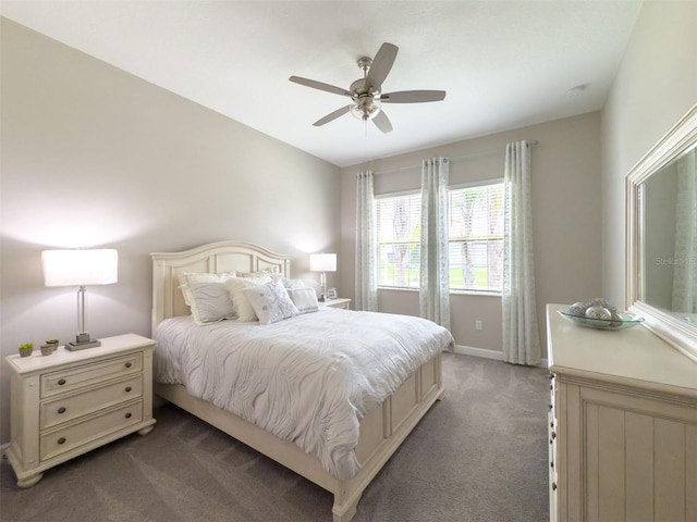 bedroom featuring baseboards, dark carpet, and ceiling fan