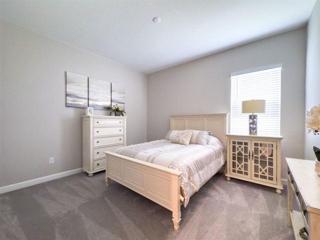 bedroom featuring baseboards and dark colored carpet
