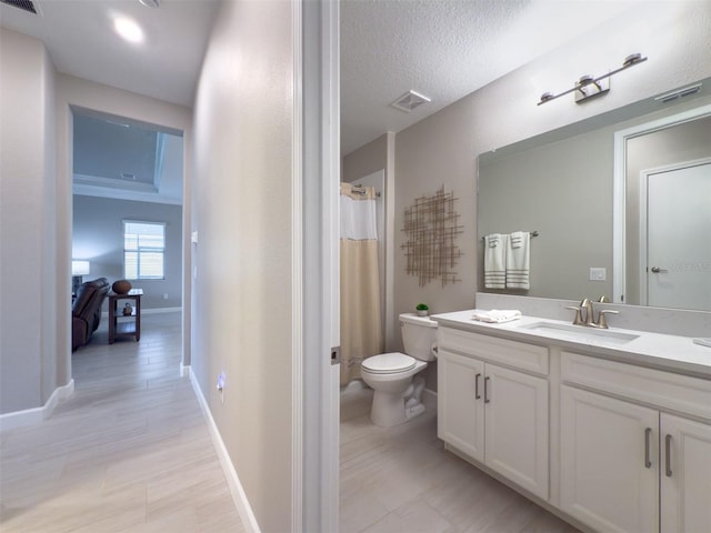 bathroom featuring toilet, vanity, visible vents, and baseboards