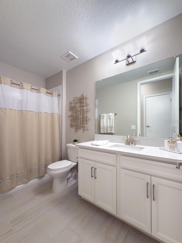 full bath featuring visible vents, a textured ceiling, vanity, and toilet
