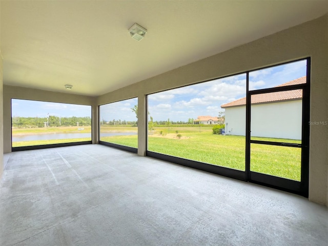 unfurnished sunroom featuring a water view