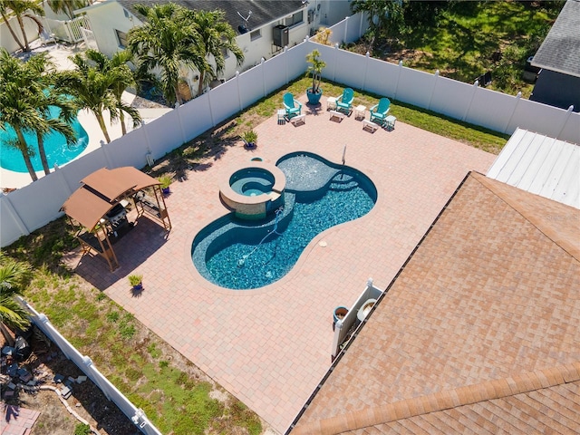 view of swimming pool with a fenced backyard, a patio area, and a pool with connected hot tub
