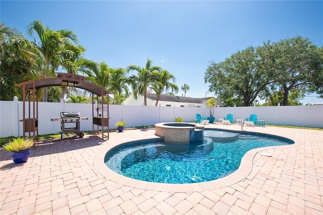view of swimming pool featuring a grill, a patio area, a fenced backyard, and a pool with connected hot tub