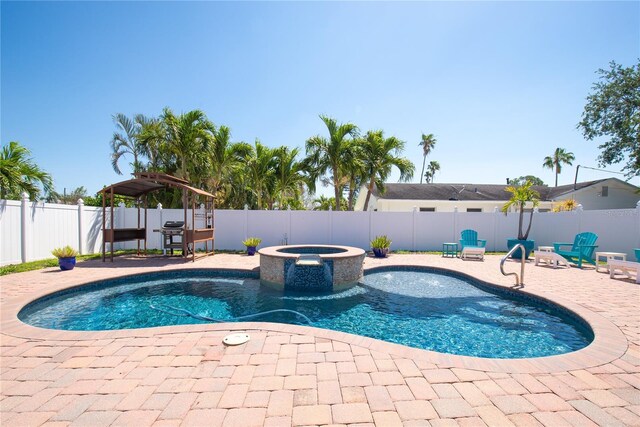 view of swimming pool featuring a fenced backyard, a grill, a patio, and a pool with connected hot tub