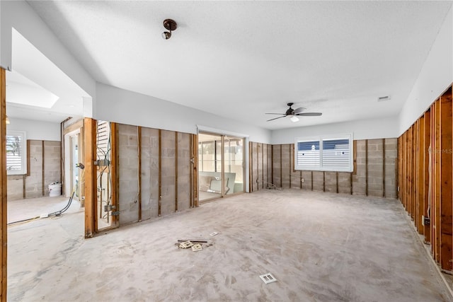 unfurnished living room with visible vents and a ceiling fan
