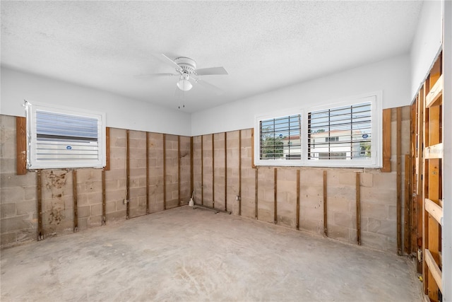 spare room with concrete flooring, a ceiling fan, and a textured ceiling