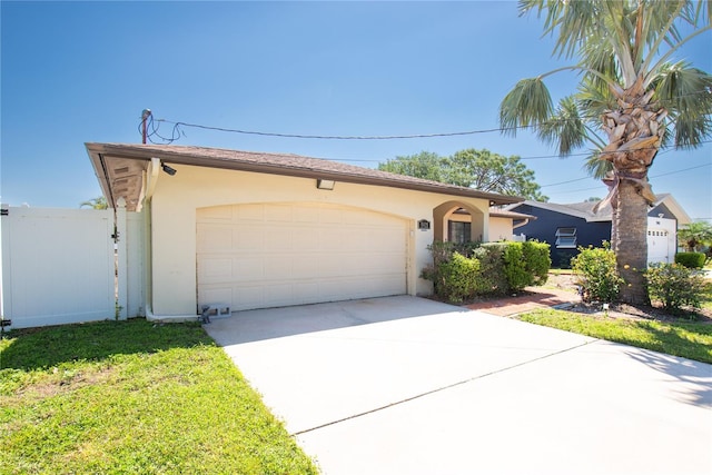 view of front facade featuring an attached garage, concrete driveway, stucco siding, and fence