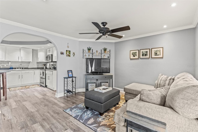 1344 Dartmouth Dr, Holiday, FL 34691 - living room with light wood-style floors, ceiling fan, arched walkways, ornamental molding, and recessed lighting