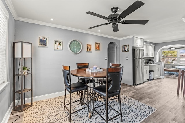 1344 Dartmouth Dr, Holiday, FL 34691 - dining area featuring arched walkways, a ceiling fan, and light wood-style flooring