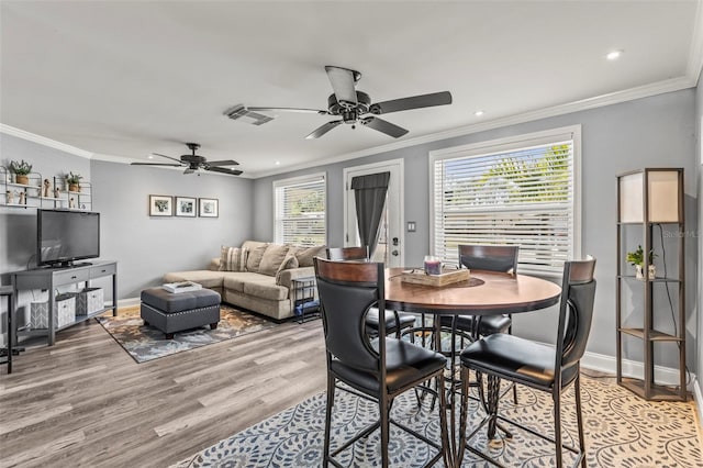 1344 Dartmouth Dr, Holiday, FL 34691 - dining room featuring ceiling fan, light wood-style flooring, baseboards, ornamental molding, and visible vents