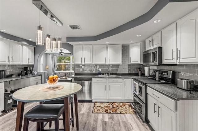 1344 Dartmouth Dr, Holiday, FL 34691 - kitchen featuring backsplash, visible vents, a sink, appliances with stainless steel finishes, and white cabinetry