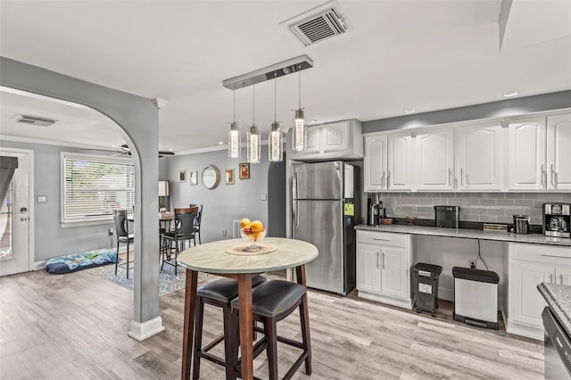 1344 Dartmouth Dr, Holiday, FL 34691 - kitchen with stainless steel appliances, light wood-style flooring, visible vents, and white cabinetry