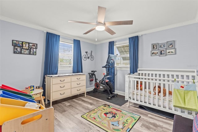 1344 Dartmouth Dr, Holiday, FL 34691 - bedroom with wood finished floors, a crib, ceiling fan, baseboards, and ornamental molding