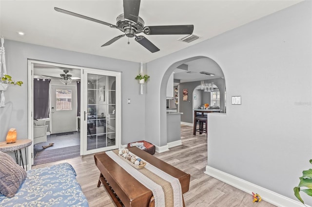 1344 Dartmouth Dr, Holiday, FL 34691 - living room featuring ceiling fan, arched walkways, visible vents, and light wood finished floors