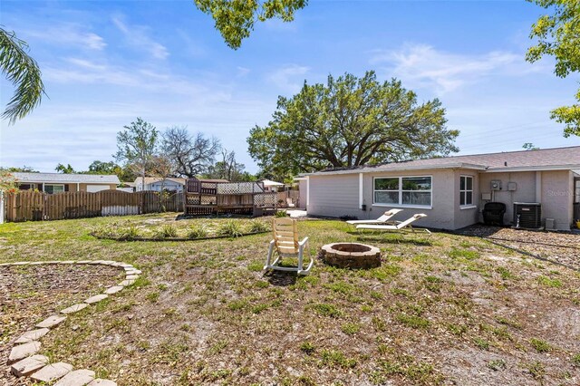 1344 Dartmouth Dr, Holiday, FL 34691 - view of yard with a fire pit, a wooden deck, fence, and cooling unit