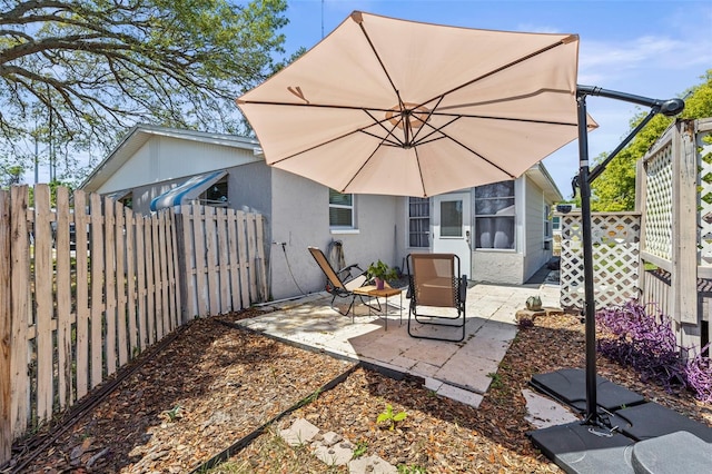 1344 Dartmouth Dr, Holiday, FL 34691 - back of property with stucco siding, a patio area, and a fenced backyard