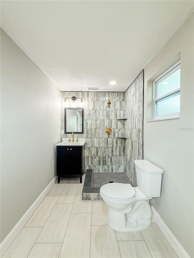 8648 78th Pl, Seminole, FL 33777 - bathroom with toilet, a tile shower, vanity, and baseboards