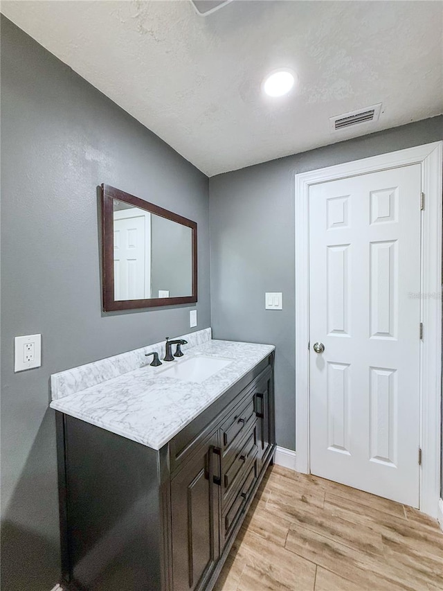8648 78th Pl, Seminole, FL 33777 - bathroom with wood finished floors, vanity, baseboards, and recessed lighting