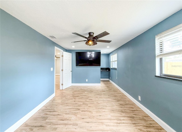 8648 78th Pl, Seminole, FL 33777 - unfurnished living room featuring ceiling fan, light wood finished floors, baseboards, and recessed lighting