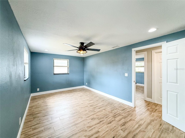 8648 78th Pl, Seminole, FL 33777 - unfurnished room featuring ceiling fan, wood finished floors, baseboards, a textured ceiling, and recessed lighting