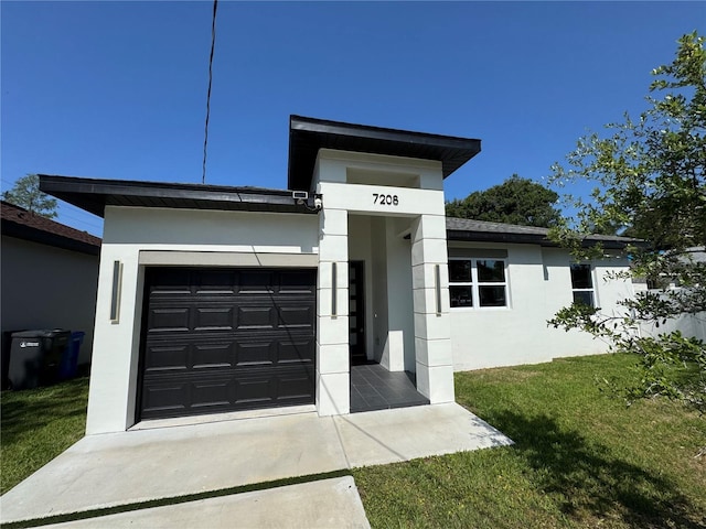 7208 N Glen Ave, Tampa, FL 33614 - view of front of house with stucco siding, a front yard, concrete driveway, and a garage