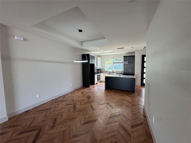 7208 N Glen Ave, Tampa, FL 33614 - interior space featuring a center island, light countertops, pendant lighting, a raised ceiling, and baseboards