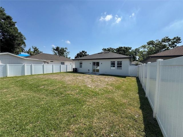 7208 N Glen Ave, Tampa, FL 33614 - rear view of property with a lawn, a fenced backyard, and stucco siding