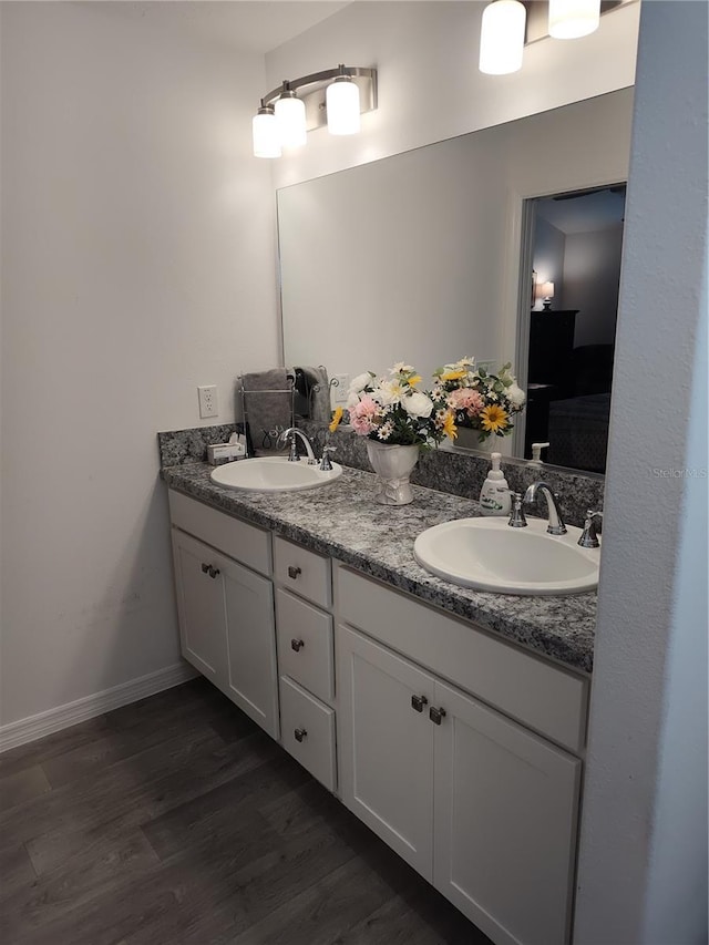 6030 Dijulio Ter, The Villages, FL 32163 - full bathroom featuring double vanity, wood finished floors, baseboards, and a sink