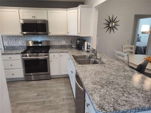6030 Dijulio Ter, The Villages, FL 32163 - kitchen with white cabinets, appliances with stainless steel finishes, decorative backsplash, and a sink