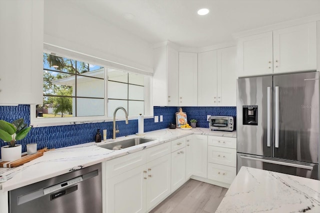 420 48th St N, Saint Petersburg, FL 33713 - kitchen featuring decorative backsplash, a sink, white cabinetry, and appliances with stainless steel finishes