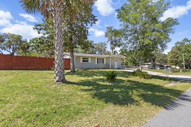 view of front of property featuring stucco siding, driveway, a front yard, and fence