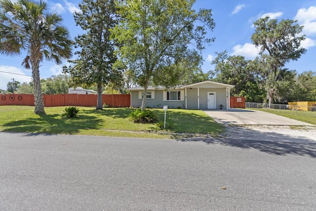 single story home with stucco siding, driveway, a front lawn, and fence