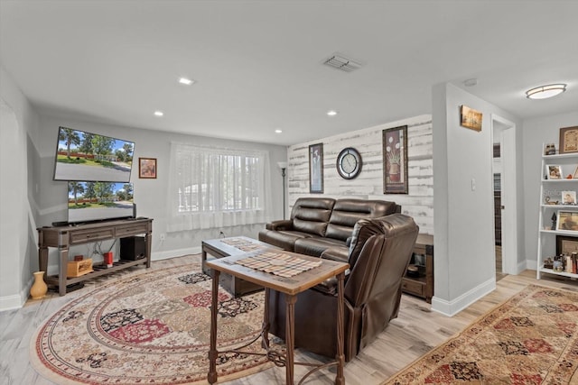 living room featuring light wood finished floors, visible vents, and plenty of natural light