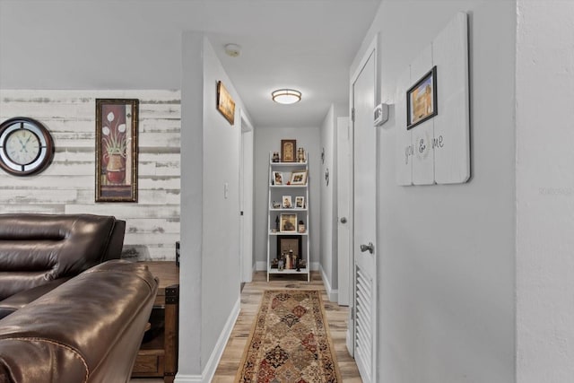hallway featuring baseboards and light wood-type flooring