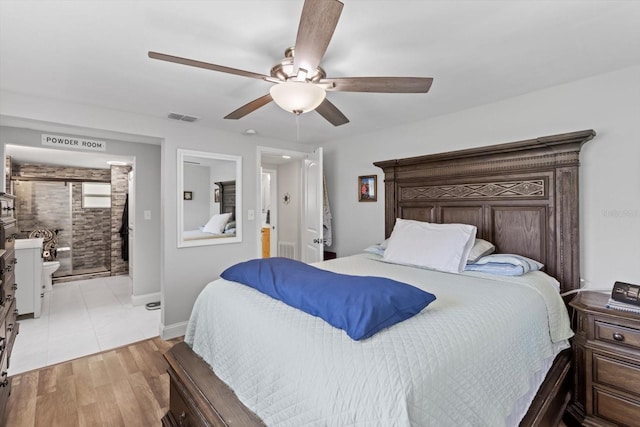 bedroom with wood finished floors, ceiling fan, baseboards, ensuite bath, and visible vents