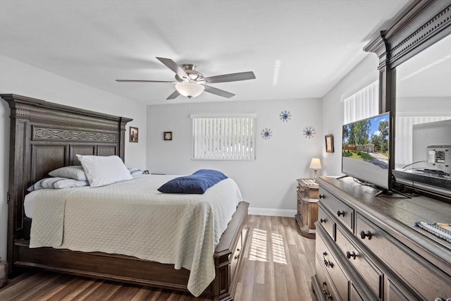 bedroom featuring ceiling fan, baseboards, and light wood finished floors