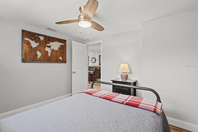 bedroom featuring ceiling fan, baseboards, wood finished floors, and visible vents