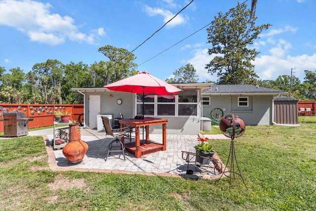 rear view of house with stucco siding, fence, and a patio area