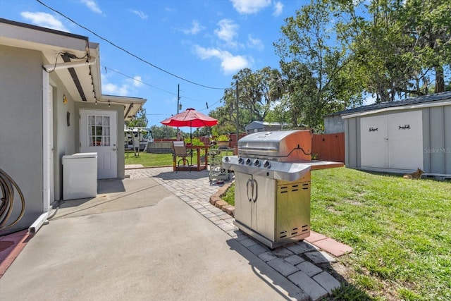 view of patio / terrace with fence, grilling area, an outdoor structure, and a storage shed