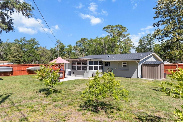 back of house featuring fence, stucco siding, a patio area, a lawn, and a sunroom