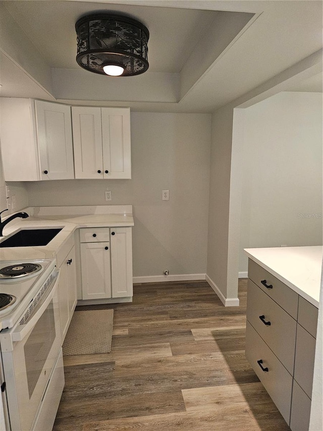 414 Danube Ave, Tampa, FL 33606 - kitchen with white cabinetry, light countertops, dark wood-style floors, electric range, and baseboards