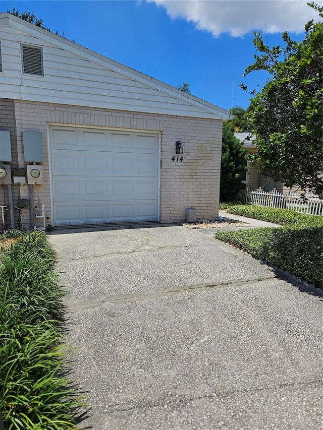 414 Danube Ave, Tampa, FL 33606 - garage featuring concrete driveway and fence